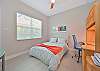 A queen bed and desk in the third bedroom