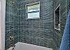 The en-suite guest bathroom features a shower-tub combo. This bathroom is also accessible from the hallway