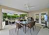 The large screened and covered lanai offers a dining area with TV and BBQ, and a seating area