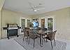 The large screened and covered lanai offers a dining area with TV and BBQ, and a seating area