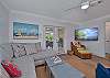 Living with comfortable seating and large smart TV. French doors open up to the large screened and covered lanai