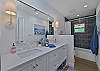 The en-suite guest bathroom features a shower-tub combo. This bathroom is also accessible from the hallway