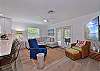Living with comfortable seating and large smart TV. French doors open up to the large screened and covered lanai