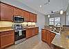 Fully equipped kitchen with breakfast bar and breakfast nook overlooking the pool area and lake
