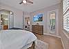 The primary bedroom with a king size bed, offers a stunning lake view