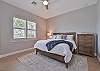 The primary bedroom with a king size bed, offers a stunning lake view