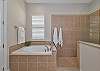 The en-suite bath features dual sinks, a relaxing garden tub, and a separate shower. 