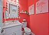 A colorful flamingo-themed powder room off the main living area means guests never need to share a bedroom bath. 