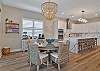 The chef’s kitchen features white shaker cabinetry, Quartz countertops, a large waterfall island with seating for four, double wall ovens, stainless appliances and a coffee bar. 