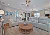 The bright open floor plan has wood-look flooring throughout and coastal décor. The living room offers two reclining sofas, extra seating and a large flat screen TV with cable. Sliding door open up to the pool area