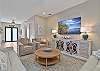 The bright open floor plan has wood-look flooring throughout and coastal décor. The living room offers two reclining sofas, extra seating and a large flat screen TV with cable. Sliding door open up to the pool area
