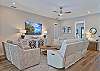 The bright open floor plan has wood-look flooring throughout and coastal décor. The living room offers two reclining sofas, extra seating and a large flat screen TV with cable. Sliding door open up to the pool area