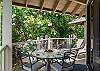 Shaded lanai dining surrounded by lush greenery