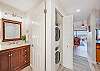 Convenient vanity area with rich wood cabinetry, adjacent to in-unit washer and dryer.