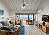 Bright living room with ocean-view balcony and coastal-inspired decor.