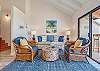 Cozy living room with rattan chairs, blue accents, balcony.