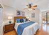 Elegant bedroom with a king bed, coastal décor, and access to a private balcony retreat.