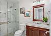 Second full bathroom with a walk-in glass shower and elegant vanity.