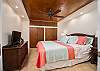 Spacious bedroom with ceiling fan, TV, and ample closet space.