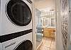In-unit washer and dryer beside bright, modern bathroom space.