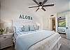Bright coastal bedroom with king bed and ceiling fan