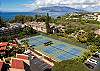 Tennis courts with stunning ocean and mountain views beyond.