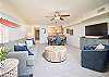 Spacious living area with comfy seating, dining table, and TV.