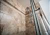 Spacious tiled shower with glass door and modern rainfall head.