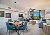 Bright living and dining area with balcony and tropical views.