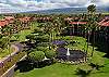 Lush resort grounds with fountain, ponds and palm trees