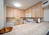 Fully equipped kitchen with ample cabinets, tiled counters, and appliances.