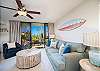 Cozy living room with sofa, balcony access, and tropical views.