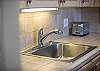 Kitchen sink with modern faucet, tiled backsplash, and toaster.
