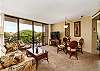 Spacious living room with tropical décor and balcony access.
