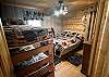 This room features a queen bed along with a set of twin bunk beds, offering comfortable sleeping arrangements for multiple guests