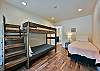 Upstairs bedroom with bunk bed with twin mattresses and an additional twin bed.
