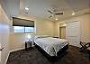 Downstairs bedroom with queen bed, closet, and ceiling fan.