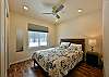 Upstairs bedroom with queen bed, ceiling fan, and closet.