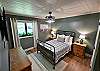 3rd bedroom with a double bed, dresser, tv, and window shades.