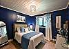 2nd Bedroom with a queen bed, portable fan, and window shades.
