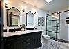 2nd bathroom with a walk in shower and double sinks.
