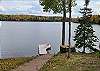Enjoy the peaceful exterior of the cabin, complete with ample parking for multiple vehicles and trailers. The property offers easy access to the water, where the shoreline and dock area are great for swimming. A boat launch is conveniently located just 2 miles south, making it simple to get out on the water. There is a slight incline from cabin to lake with concrete stairs