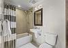 A second full-size bathroom offers a bathtub/shower combination, toilet, sink and storage.