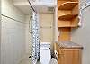 Tiled walk-in shower with a bidet toilet.
