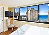 Spacious bedroom includes a flat-screen TV and lounge chair.