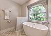 Primary ensuite bathroom double vanity, walk-in shower, relaxing soaking tub, and toilet