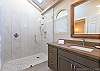 Hall bath with walk in shower, also accessed from 2nd master bedroom. A door is between toilet section and shower