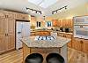 Full open kitchen with bar stool seating and 4 person breakfast table 