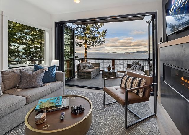 There is a cozy fireplace in the living room with an accordion glass wall opening the entire house to the stunning Salish Sea 

**Not suitable for children under 16 due to high bank waterfront.**