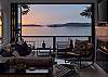 View from the living room looking out to the spacious deck and sunset 